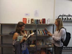 Zwei Frauen stöbern im offenen Bücherschrank